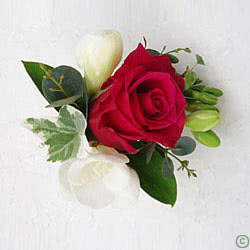 This is a Wedding Day Flower Corsage, using a red rose and white freesia coming with a greenery foliage backing.