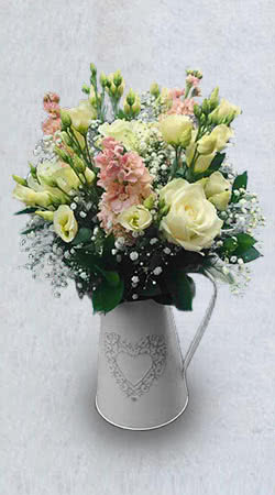 This is a picture of a Wedding Reception Flower Table Decoration Jug using roses, lisianthus, stocks and gypsophila.