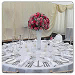 This is a picture of a Wedding table flower display in pink and white flowers supplied in a long vase.