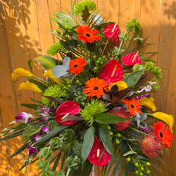 This is a Wedding Flower Pedestal, it comes with orange Gerbera, red Anthurium, yellow Calla Lily, Orchids, Shamrock Bloom Chysanthemum flowers and green palm leaf foliage.