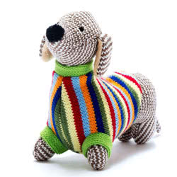 Best Years Knitted Sausage Dog Baby Rattle. Made from 100% acrylic yarn with recycled polyester stuffing. Coming with a gorgeous multi-coloured knitted coat, over a herring bone style body, black button nose and hand stitched eyes, plus  a gentle rattle.