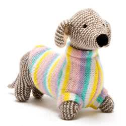 Best Years Knitted Sausage Dog Pastel Jumper Baby Rattle. Made From 100% acrylic yarn with recycled polyester stuffing in a brown and white patterned fur, with a cute black snout, stitched eyes and little ears. Finished with the most adorable pastel jumpe