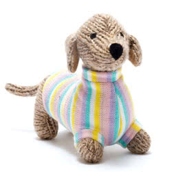 Best Years Knitted Sausage Dog Pastel Jumper Soft Toy. Made from 100% acrylic yarn with recycled polyester stuffing with a lovely two-tone brown knitted fur, and stylish turtle neck pastel jumper. Featuring hand stitched eyes and a cute little black butto