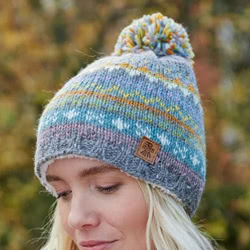 Pachamama Knitwear Braemar Bobble Beanie hat featuring fair isle patterns on a grey background, 100% wool, fleece lined.