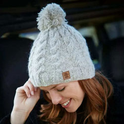 Pachamama Knitwear Cairngorm Bobble Beanie Oatmeal hat featuring a simple oatmeal cable knit, wool-mohair mix, fleece lined.