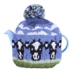 Pachamama Dairy Cow Tea Cosy. This handknitted, wool tea cosy comes with a bobble and fleece lining for warmth. It has a Friesian cow and scudding clouds pattern. They are all made in Nepal using local wools 
and natural dyes to UK designs and fair trade