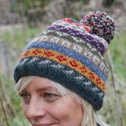 Pachamama Knitwear Elveden Bobble Beanie hat, handknitted, made from 100% wool, with a partial Sherpa fleece lining for extra comfort and warmth. This classic fair isle design consists of earthy colours and intricate handknitted patterns.