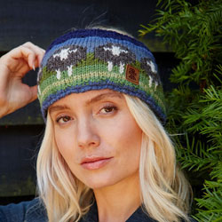 Pachamama Knitwear Flock of Herdwick Sheep Headband ear warmers, featuring black sheep on a green-blue background, 100% wool, fleece lined.