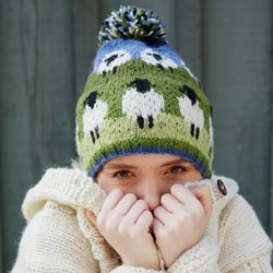 Pachamama Flock of Sheep Bobble Beanie. This hand 
knitted Flock of Sheep Bobble Beanie is made from 
100% wool with a 
fleece lining and comes with a black faced sheep pattern complete with a green, white and blue bobble.