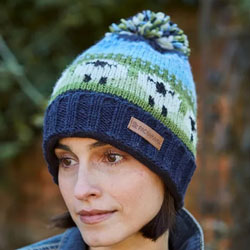 Pachamama Flock of Sheep Roll Back Bobble Beanie Hat features sheep pattern on a blue & green background, 100% Wool, fleece lined.