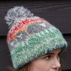 Pachamama Knitwear Hazy Herdi Bobble Beanie hat featuring a black sheep animal pattern in autumnal colours, 100% wool, fleece lined.