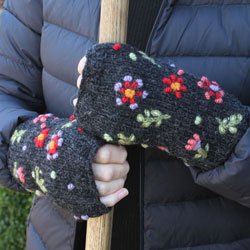 Pachamama Knitwear Lugano Handwarmer Charcoal fingerless gloves featuring embroidered flowers on a charcoal background, handknitted, 100% wool, fleece lined.