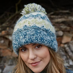 Pachamama Totnes Bobble Beanie Spruce Hat featuring fair isle patterns in teal, blue, cream and  green, 100% Wool, fleece lined.