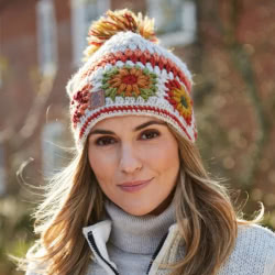 Pachamama Knitwear Woodstock Oatmeal Bobble Beanie Hat featuring sunflowers in earthy tones on an oatmeal background, 100% Wool, fleece lined.