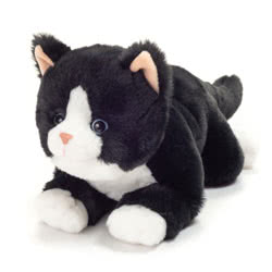 Teddy Hermann lying Black & White Cat soft toy 30cm with a black fur body, white paws & face, long tail, upright ears and pink nose.