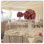 This is a picture of pink and white Wedding table flower displays in situ at a wedding reception.