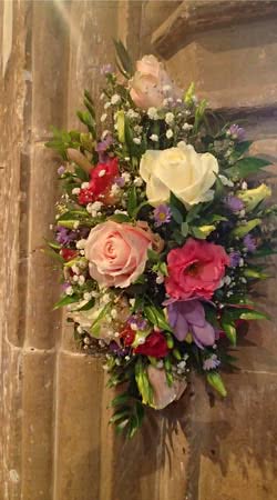 This is a Wall Hanging Wedding Flower Display using roses, gypsophila, lisianthus and ruscus foliage.